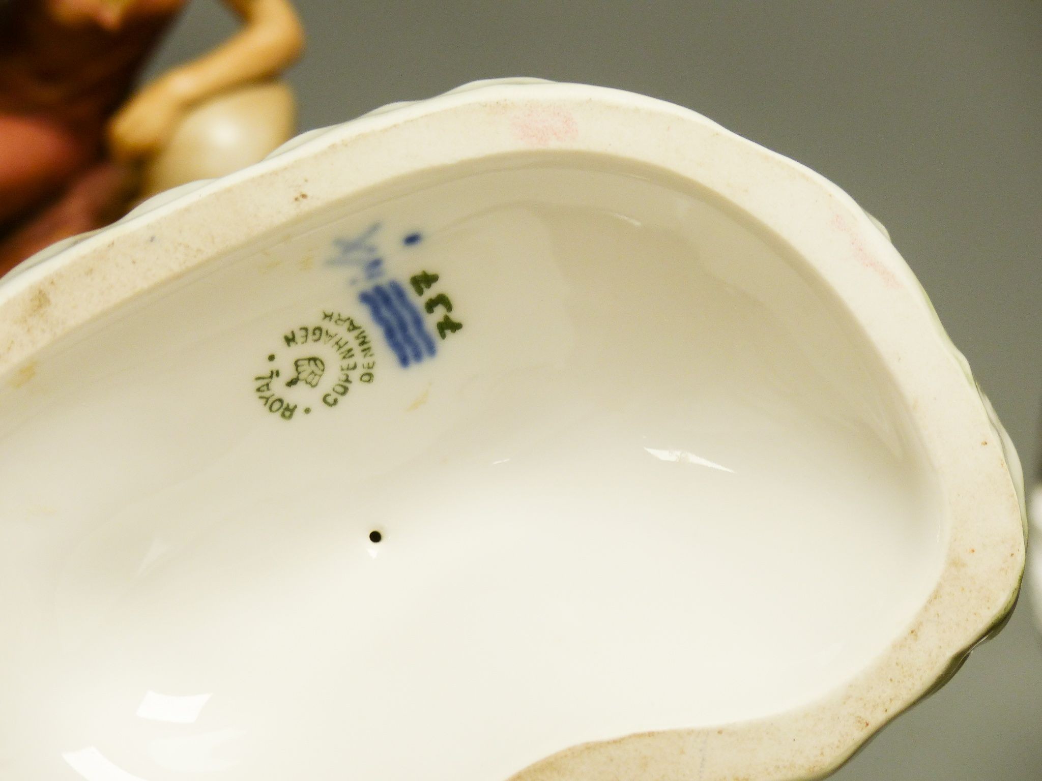 A Royal Dux figural dish, 26cm high and a figure of a donkey and a Royal Copenhagen group of a faun riding a goat, 22cm long